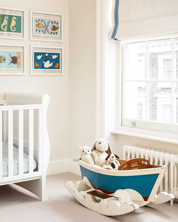 A nursery by Amelia McNeil Interior Design is set to welcome a tiny sea captain to-be complete with a pint-sized boat and vintage nautical prints. Shades are fittingly trimmed with the Nantucket Strie Border from the Samuel & Sons Regatta collection of indoor/outdoor trim. Photography by David Butler. 
