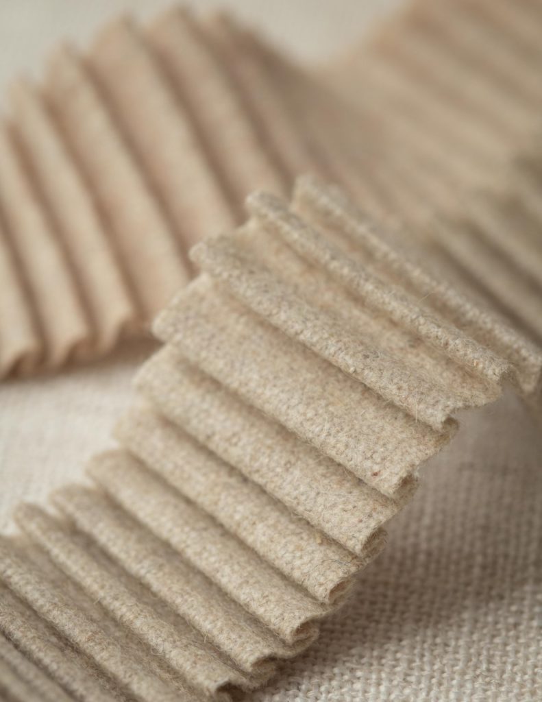 Pleated wool borders in soft neutral colors.