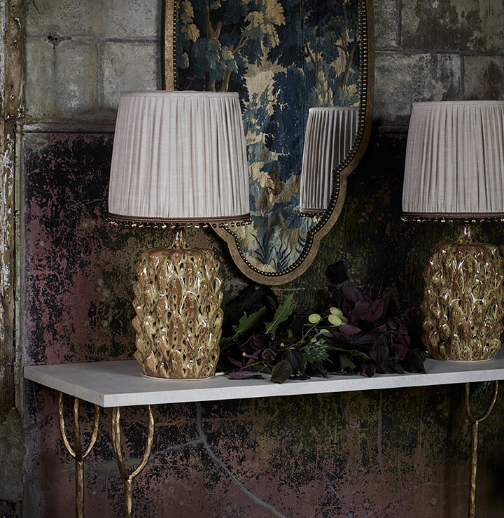 An entryway featuring two table lamps with beaded fringe.