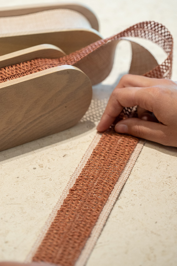 A solid tape can be seen between the open weave of a macrame border on top.