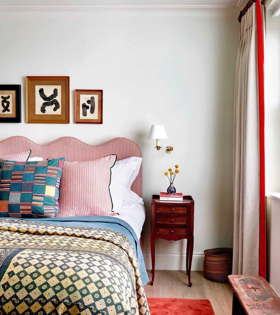 A bedroom with a vibrant pink headboard and colorful bedding, creating a lively and cheerful atmosphere.