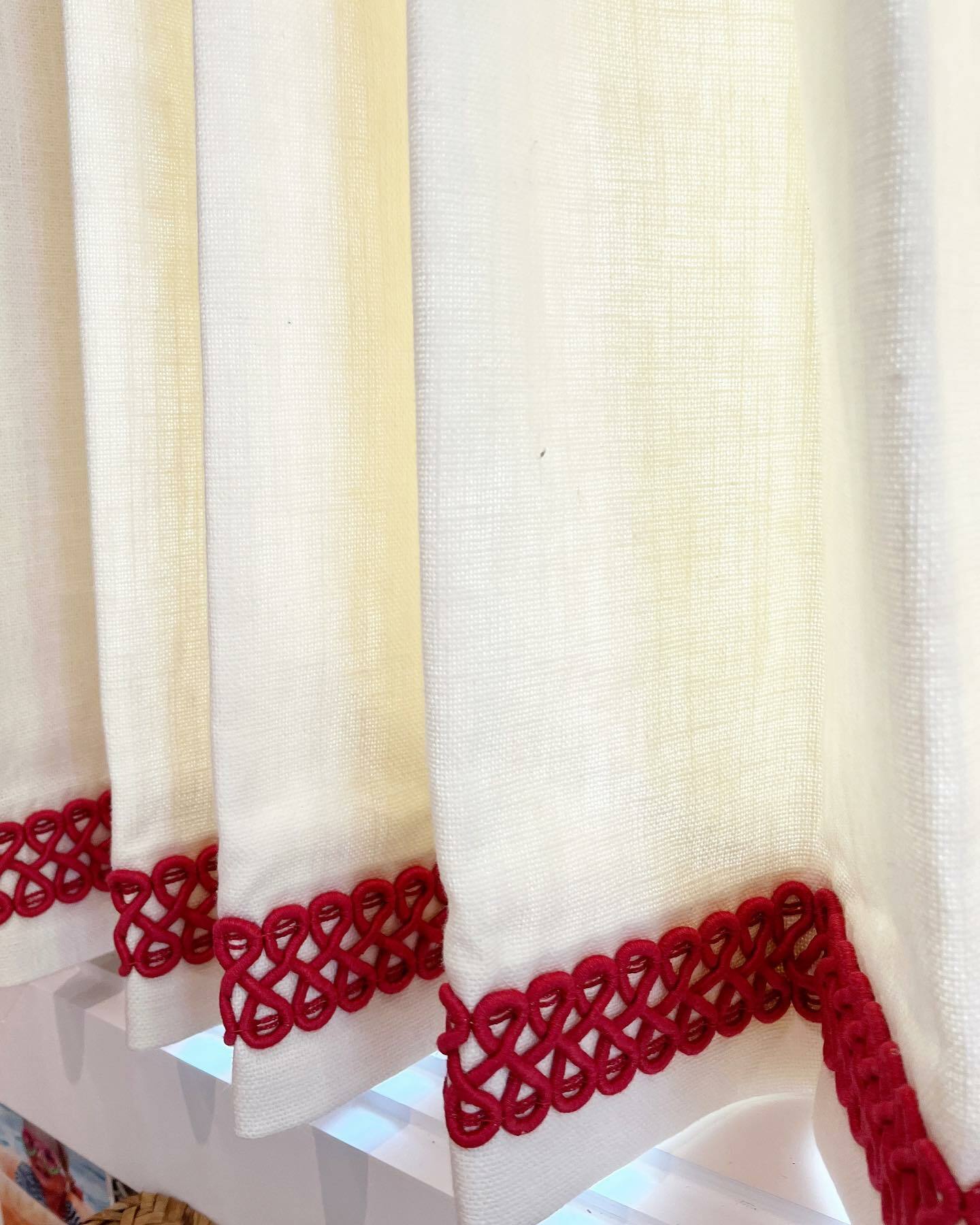 A close-up of a curtain with red trim, adding a touch of elegance to the room's decor.